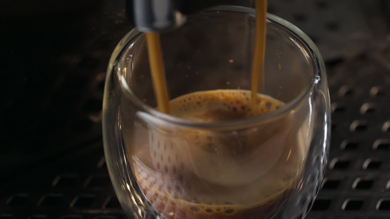Studio close up of a glass tumbler filling with machine coffee