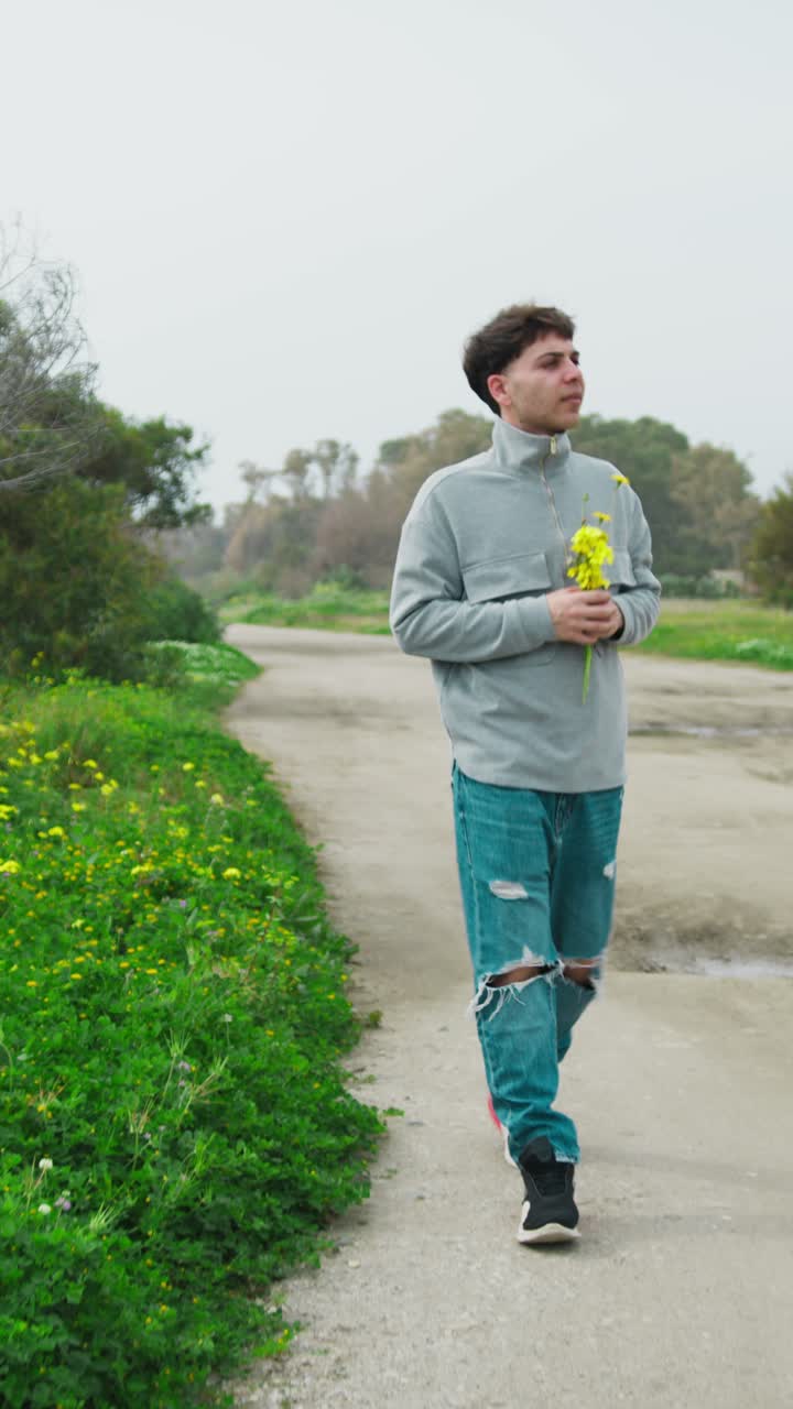 Man In The Nature Walking With Yellow Flowers In The Hand
