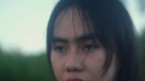 slow-motion close-up shot of young woman's face and blank expression as she walks outdoors. -selective focus