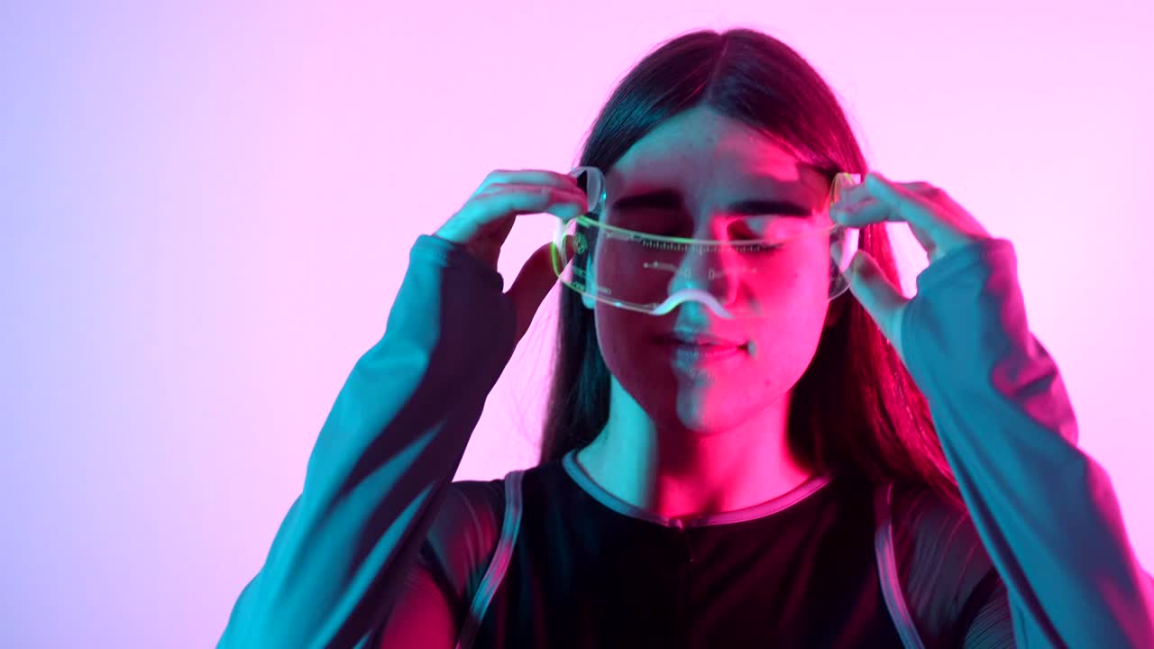 Young adult wearing futuristic glasses in a neon environment