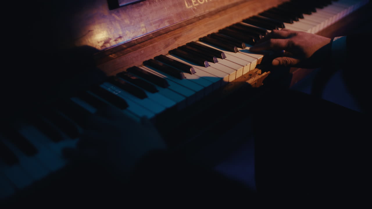 persona tocando el piano en la oscuridad