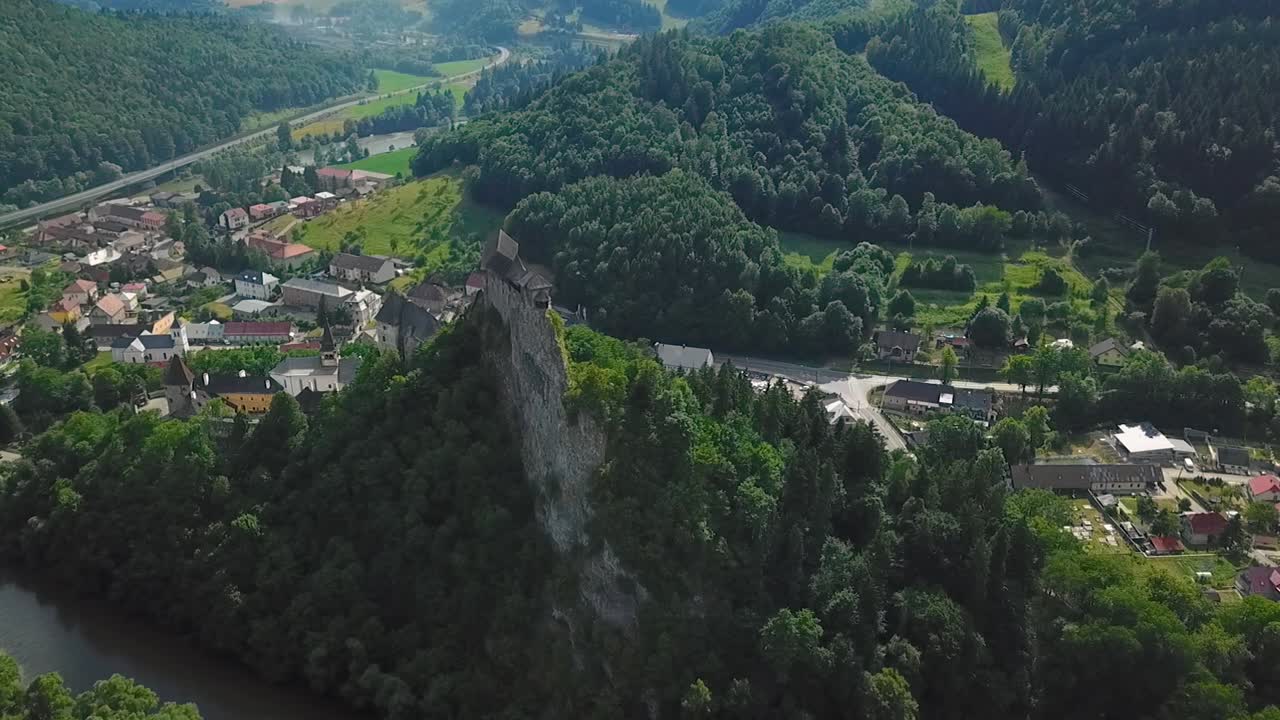 castillo de orava en eslovaquia desde lejos, enfocado en el castillo y el pueblo cercano, orbitándolo, 50fps + 100ss