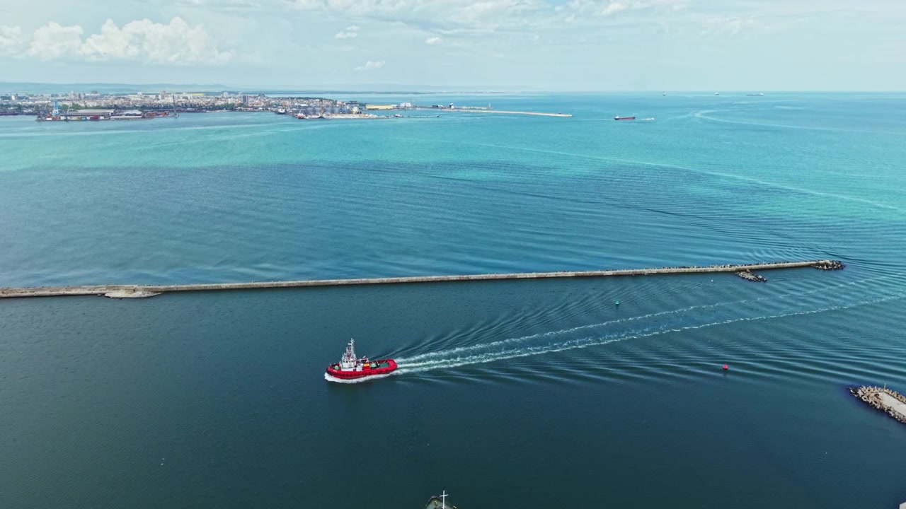 Barcos navegando por águas calmas em um porto durante o dia perto de uma cidade costeira.