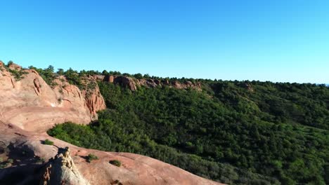 Backwards-aerial-dolly-revealing-slick-rock-and-hoodoo-near-Moab,-Utah