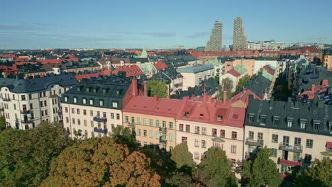 old urban apartment blocks and high-rise buildings by green city garden in stockholm