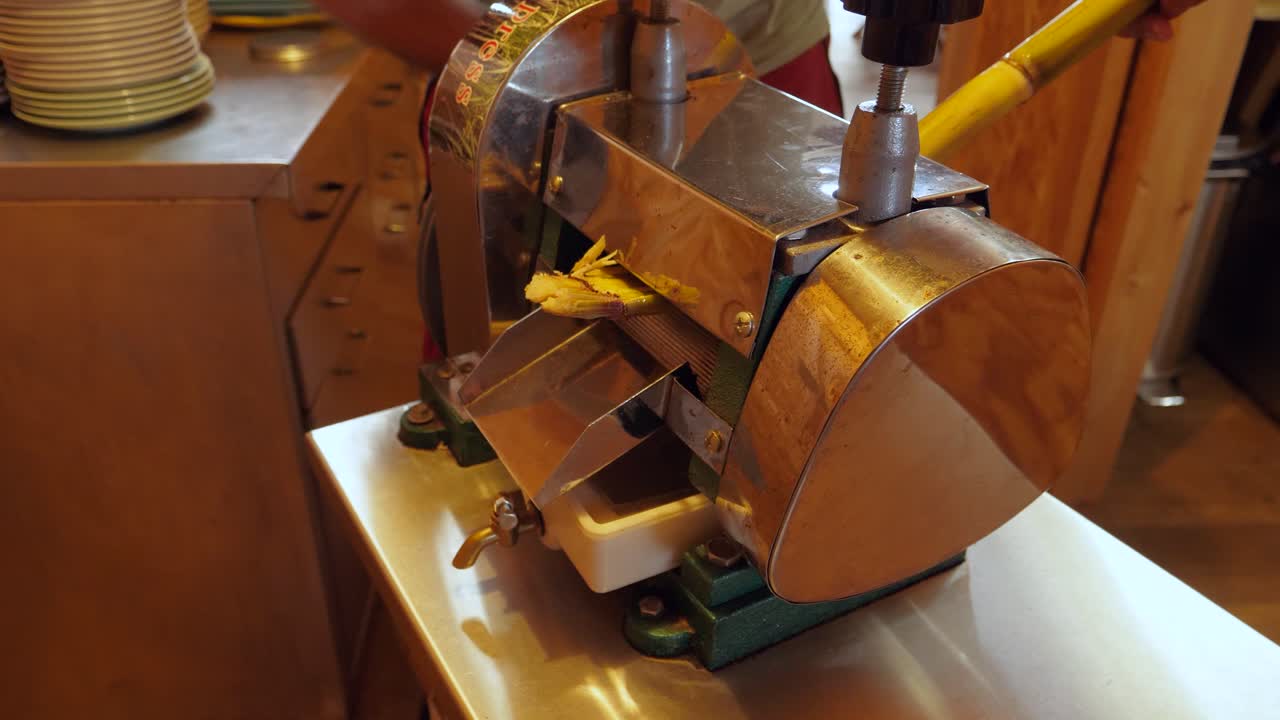 jugo de caña de azúcar extraído con una máquina de exprimir manual