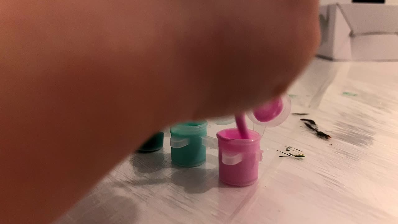 Close-up. The boy soaks the brush in the paint container. Painting at home. Children's fun.