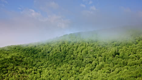 sweeping overhead shot of mist curling around the smoky mountain peaks