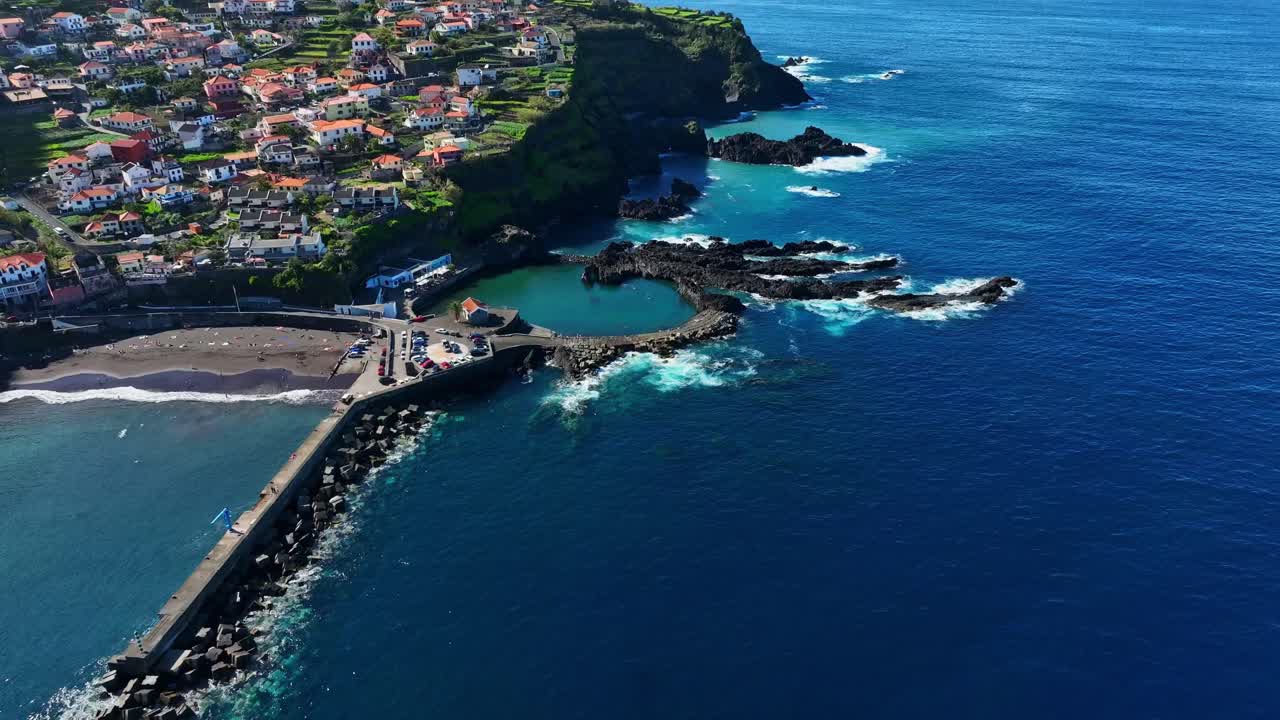 Veduta aerea delle piscine naturali di Seixal, mare blu, spiaggia e città a Madeira.