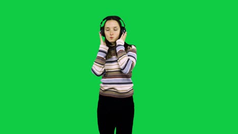 Chica-Feliz-Con-Auriculares-Baila-Frente-A-La-Pantalla-Verde