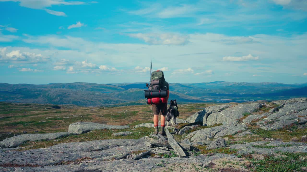 excursionista con mochila y malamute de alaska en mefjellsvatnet en indre fosen, trondelag, noruega