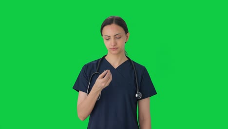 Doctora-India-Inspeccionando-La-Pantalla-Verde-De-Tijera-De-Instrumentos-Quirúrgicos