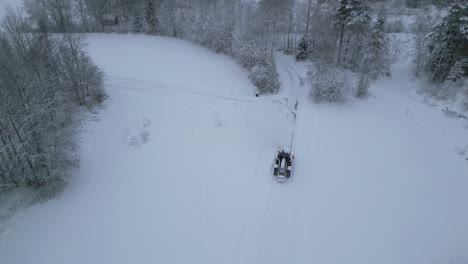 snow plower cleaning countryside roads, aerial view