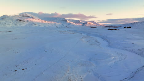 Gefrorener-Gewundener-Fluss-Inmitten-Der-Schroffen-Schneebedeckten-Landschaft-Islands-Nach-Der-Goldenen-Stunde