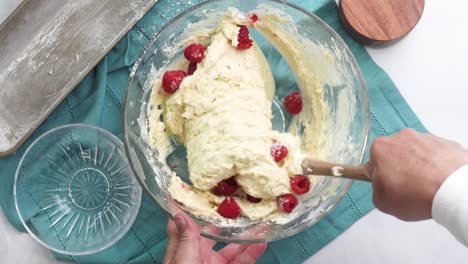 making a dessert called red raspberry tea cake made with fresh berries and vanilla buttercream frosting. great for tea parties. adding into the batter, fresh red raspberries and mixing into the bowl