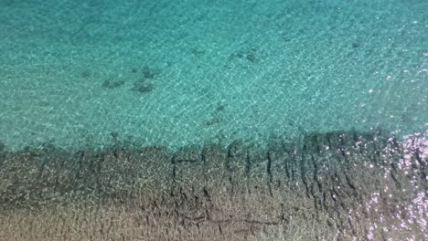 Overhead-drone-clip-over-beautiful-beach-with-waves-crushing-the-shore-in-Kavala,-Macedonia,-Greece