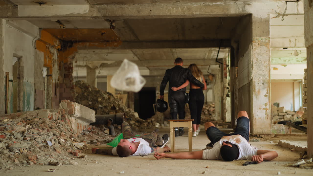 포옹하는 커플은 오래된 건물에서 죽은 범죄자를 떠납니다.