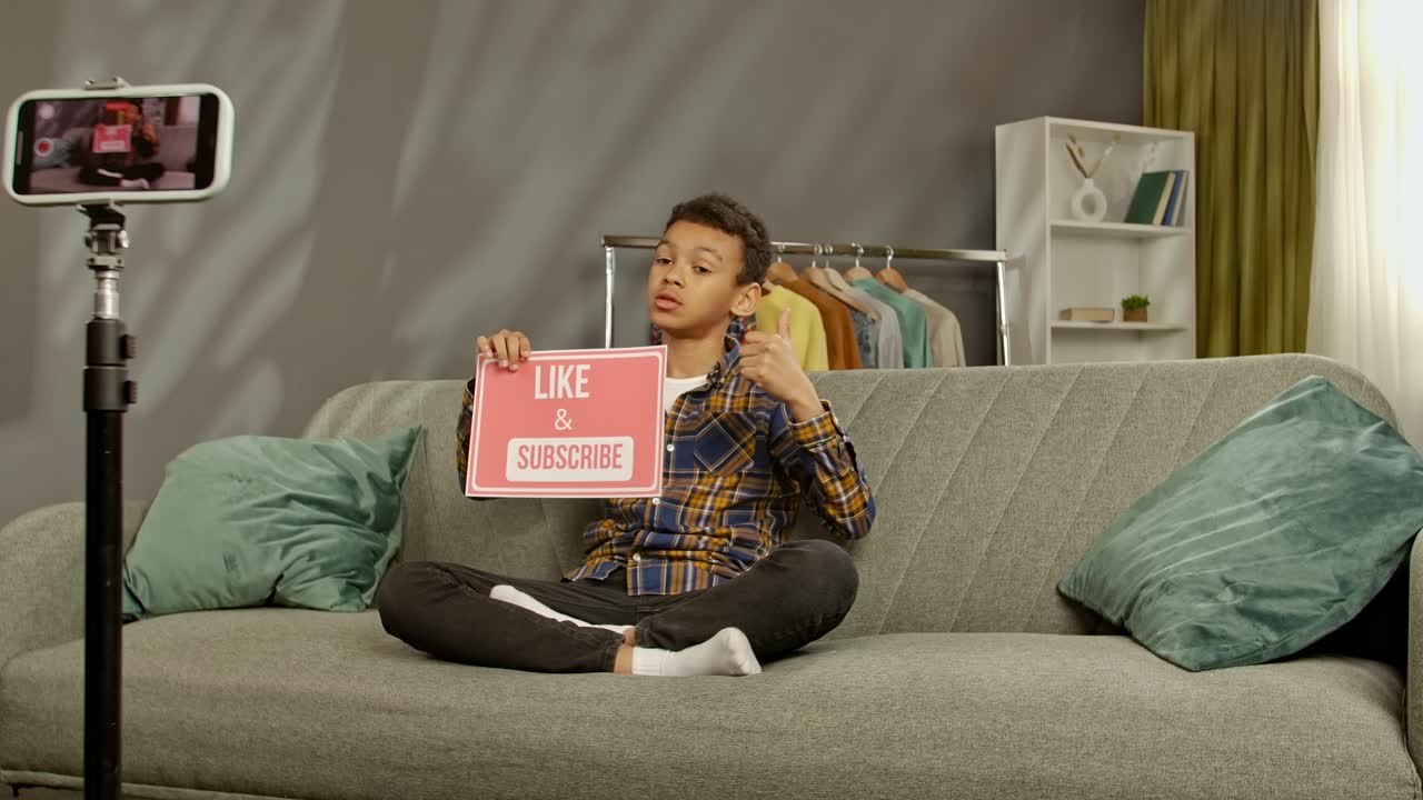 Young boy vlogging, asking for likes and subscribes