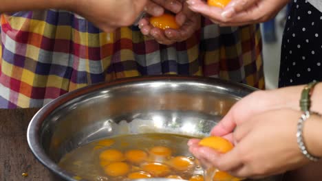 cerca de las manos separan las yemas de huevo de las claras de hule en las recetas de postres tailandeses.