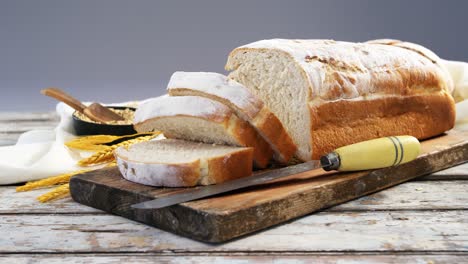 Bread-loaf-with-knife,-wheat-grains-and-oats