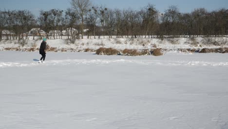 ice skating on frozen lake. winter outdoor activities. woman in white figure skates is skating on frozen pond. female rides on skates on ice