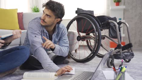 disabled teenager using a wheelchair is studying at home.