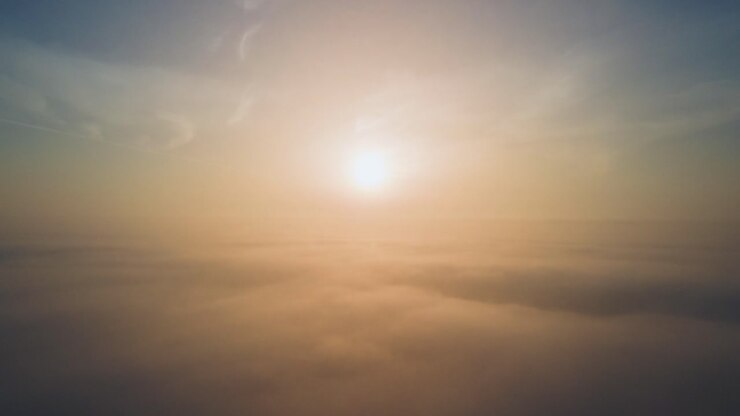 Aerial drone shot of atmospheric sunrise above the clouds