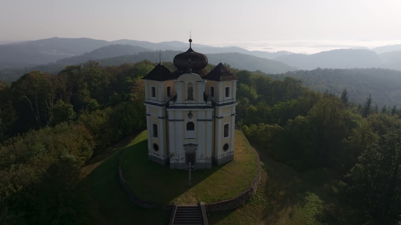 Vista aerea della chiesa di Kostel sv. Jana circondata da foreste e colline