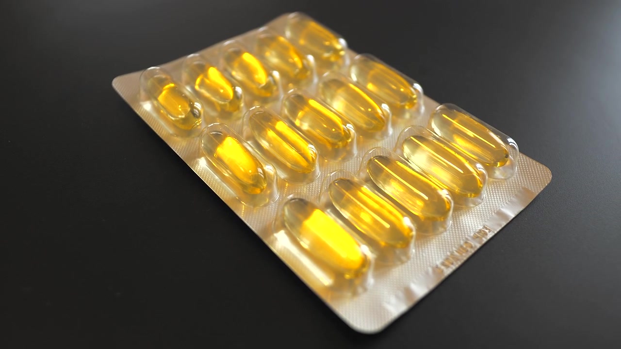 Blister Pack of Yellow Gelatin Capsules on Dark Surface