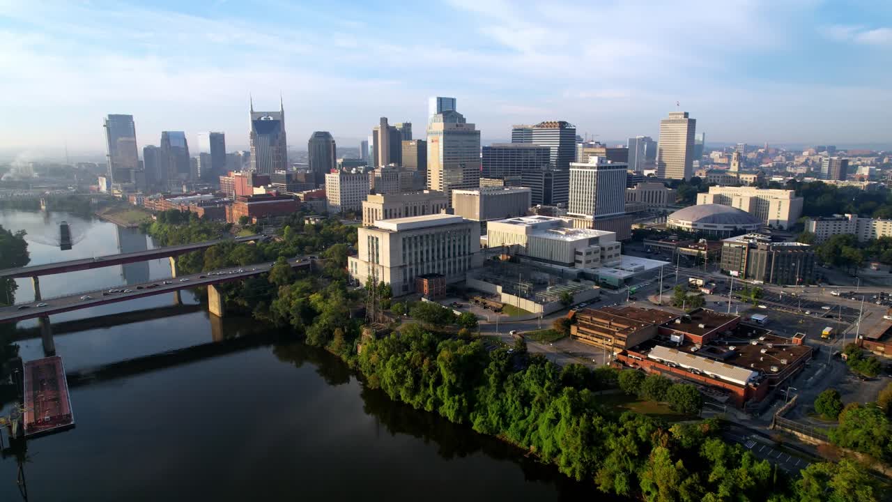 Hurtig luftoptagelse ind over Nashvilles skyline i Tennessee med udsigt over Cumberland-floden.