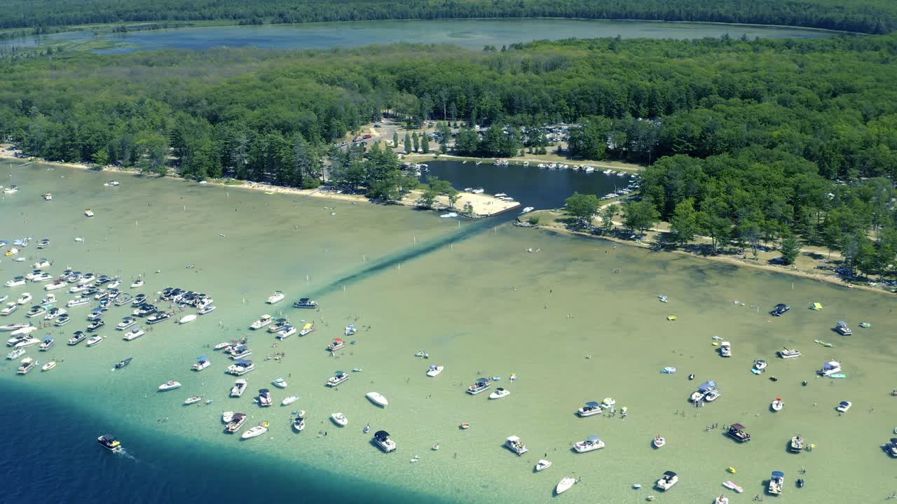 Aerial Pan Up Shot of Lagoon and small Lake with Boats and People in Shallow Waters of a Glacial Lake in Michigan