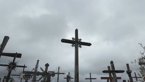 multiple wooden crosses stand against a cloudy grey sky at the hill of crosses pilgrimage site in lithuania, symbolising faith, hope, and remembrance.