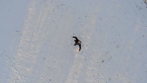 person dances awkwardly with the arms and legs in the snowy landscape