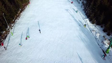 Aerial-view-of-a-snowboarder-falling-down,-getting-up-and-continuing-to-snowboard-down-slope-in-Topolita-Snow-Summit,-Transylvania---Romania