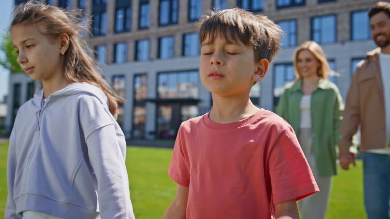 Family couple strolling together weekend with children in sunny neighbourhood