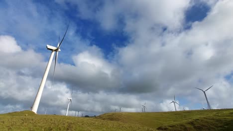 tomada de ángulo bajo de las turbinas eólicas en un parque eólico en un paddock en manawatu, nueva zelanda