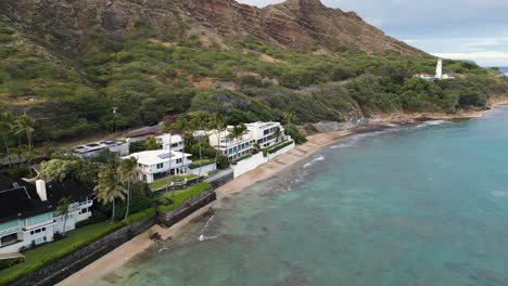 aerial - backward panning view of waterfront condos near hills at daytime