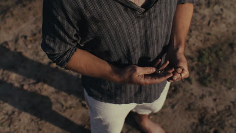 man's hands holding a string outdoors