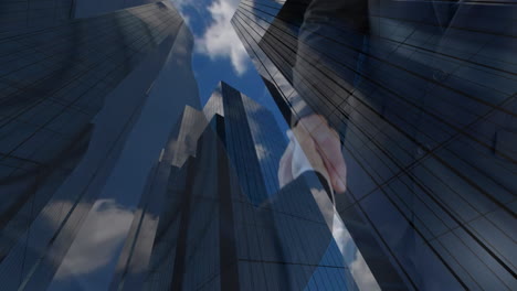 businessmen shaking hands with modern office buildings in the background