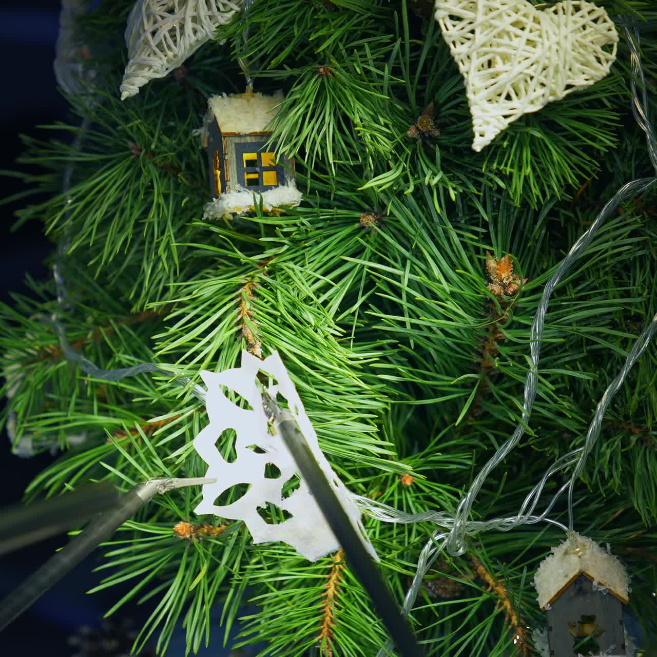 Christmas tree and metal cyborg arms. Robotic equipment for decorating New Year tree with paper snowflake. Intelligent machinery