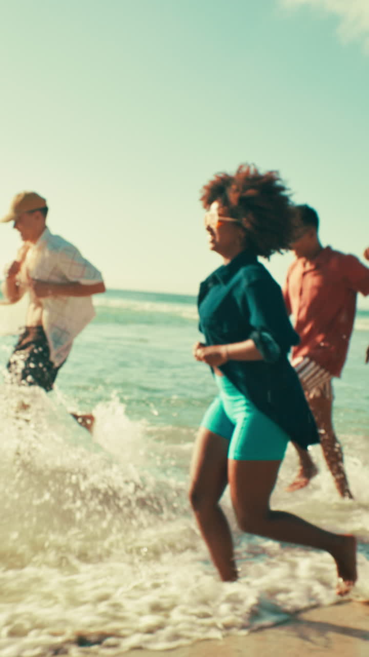 Joyful Young People Running and Splashing in Ocean Waves on a Sunny Beach