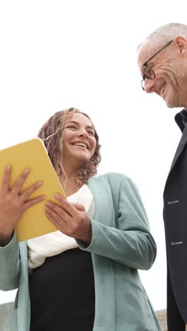 businesswoman showing document to senior colleague. vertical