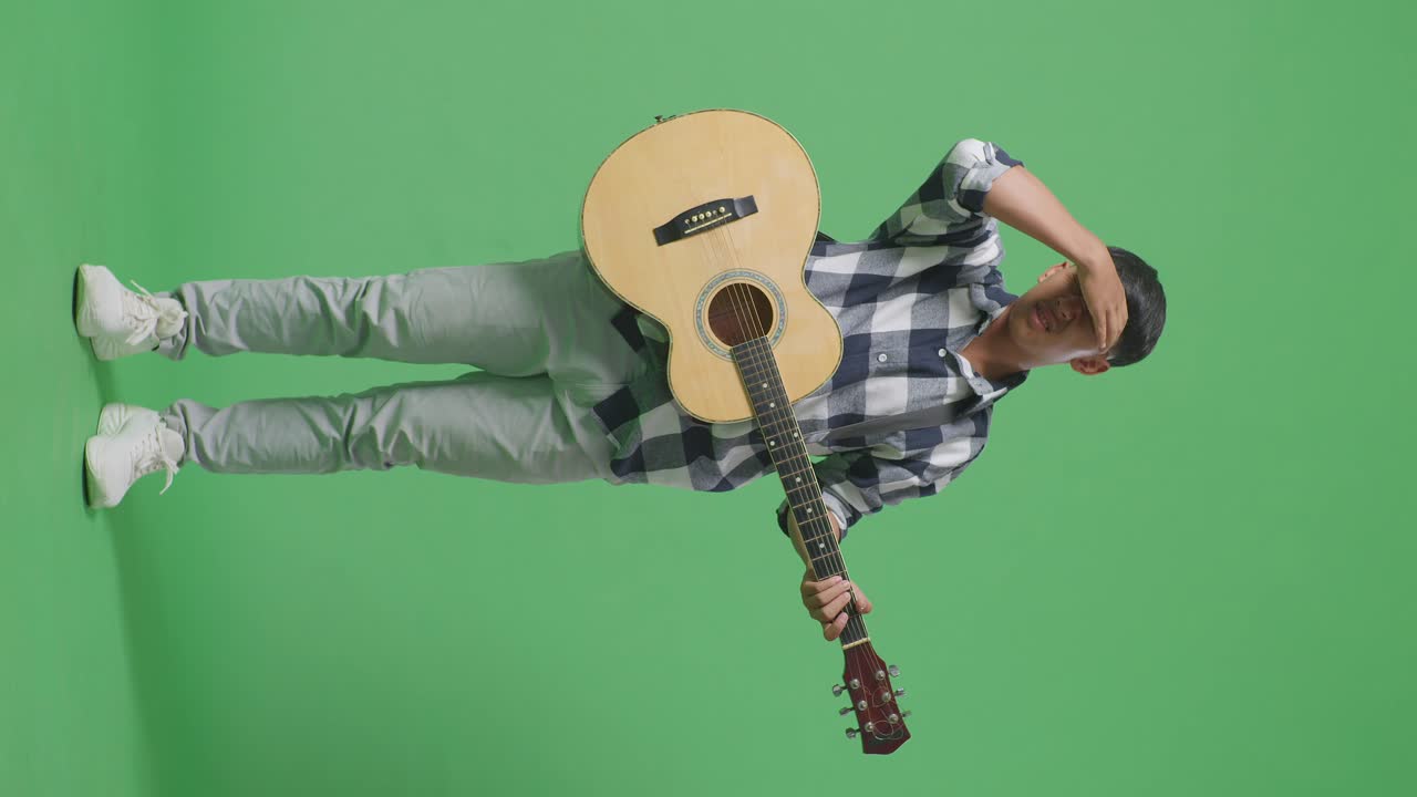 Uomo con chitarra che sembra turbato.