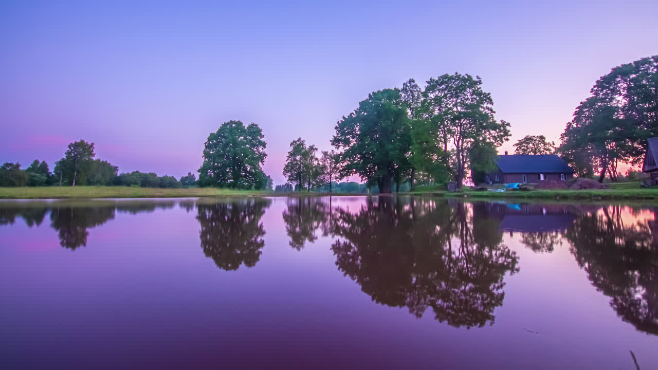 Cottage in un villaggio vicino a un piccolo stagno o lago in timelapse.