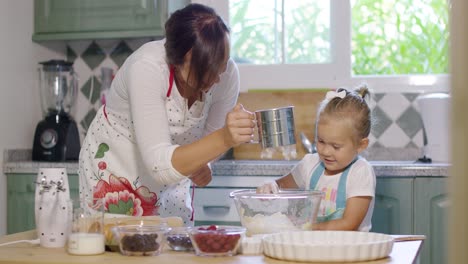 madre y hija jóvenes horneando en la cocina