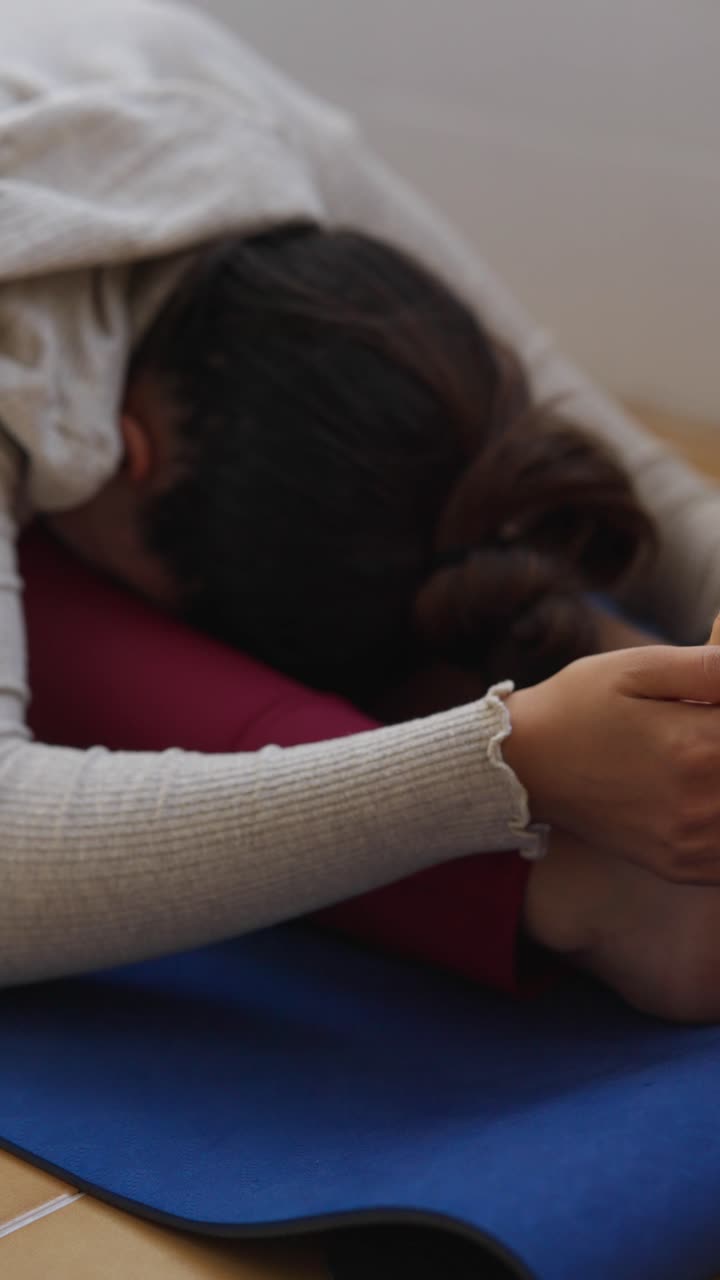 Woman practicing seated forward bend yoga pose