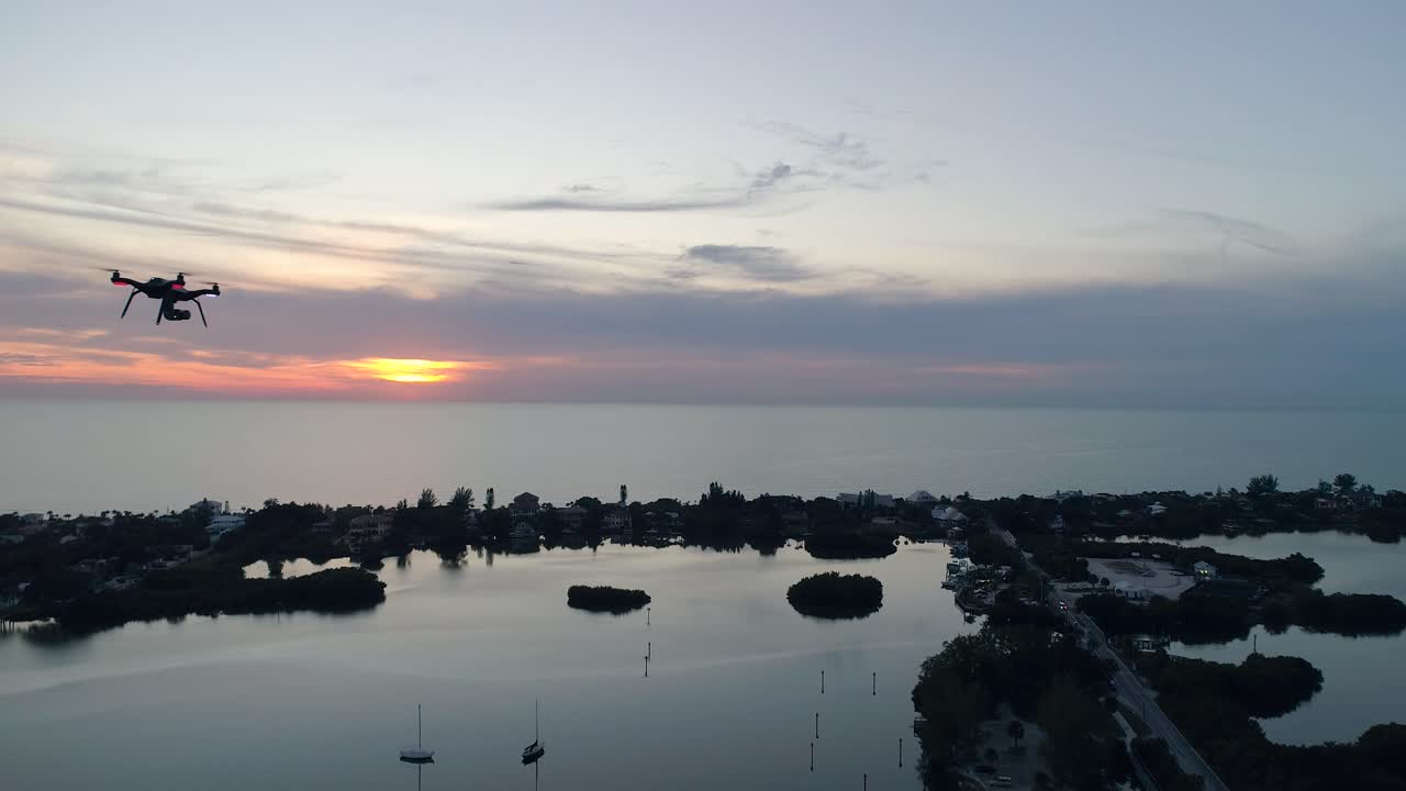 해가 지면 멀리 하늘로 날아가는 드론의 공중 촬영