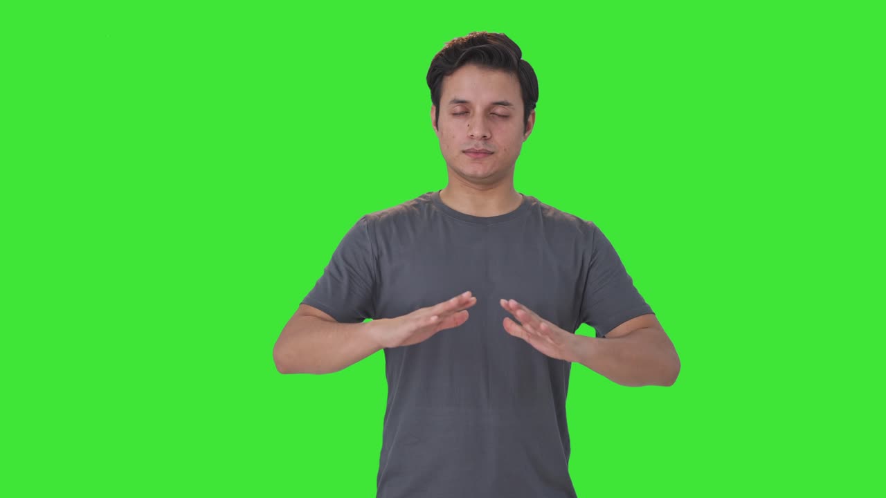 인디언 남자가 휴식을 취하고 요가 녹색 화면을하고 있습니다.