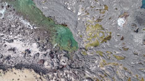 Drone-view-of-the-small-swimming-basin-at-Pointe-au-Sel-in-Saint-Leu,-Reunion-Island,-with-a-slow-left-rotation-movement