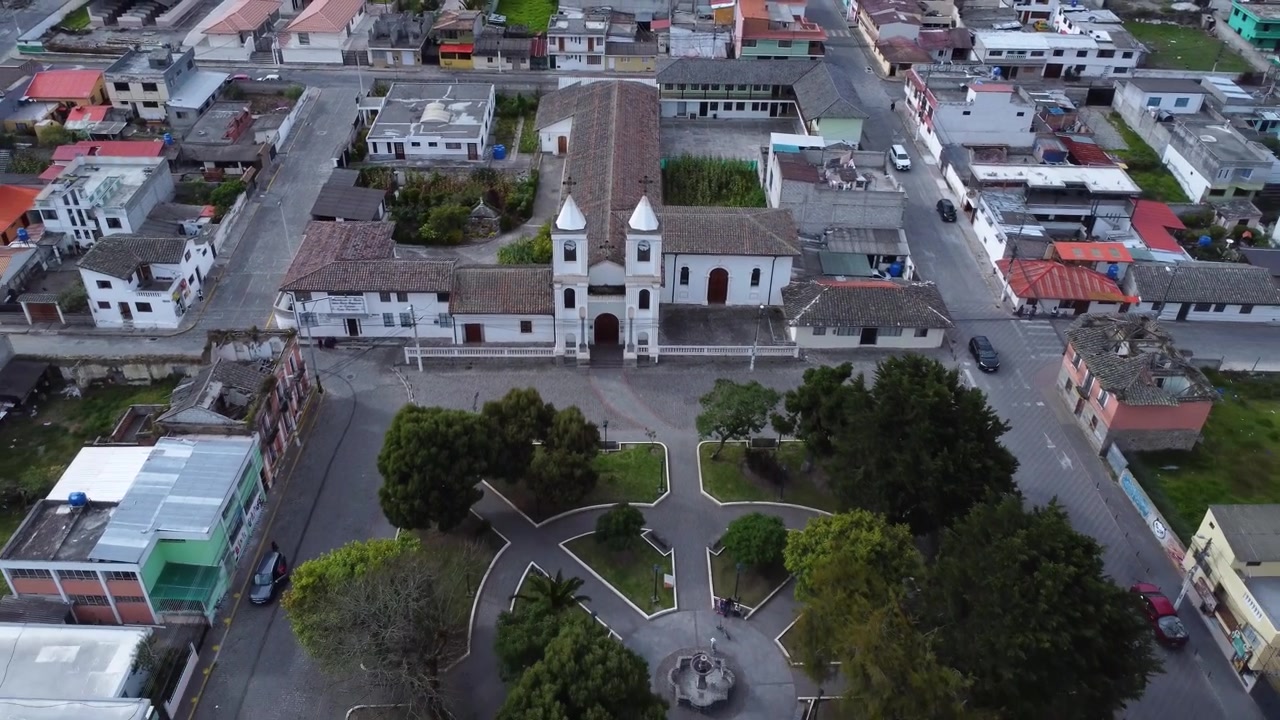 Il drone si allontana dalla chiesa di Calacali rivelando il monumento Mitad del Mundo e la piazza della città in Ecuador